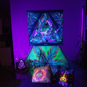 Peut inclure: Une chambre &agrave; coucher avec une tapisserie psych&eacute;d&eacute;lique accroch&eacute;e au mur. La tapisserie est un triangle noir et vert avec un motif g&eacute;om&eacute;trique. Il y a deux oreillers sur le lit, l'un avec un motif de mandala color&eacute; et l'autre avec un motif arc-en-ciel. La pi&egrave;ce est &eacute;clair&eacute;e par des lumi&egrave;res violettes et bleues.