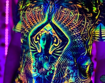Op de afbeelding: Een zwart shirt met een neon geometrisch ontwerp en een centrale figuur in een gebedshouding. Het ontwerp bevat blauwe, groene en gele tinten, met het woord "Fractalika" rechtsonder.