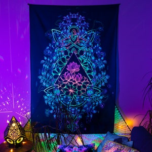 May include: A black tapestry with a glowing, neon-colored design of a lotus flower inside a triangle surrounded by a circular pattern of leaves. The tapestry is hanging on a wall with a purple background.