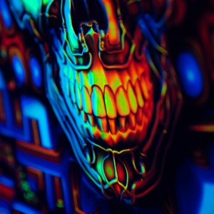 May include: A close-up of a neon green, blue and orange skull with a toothy grin. The skull is against a background of colourful geometric shapes.