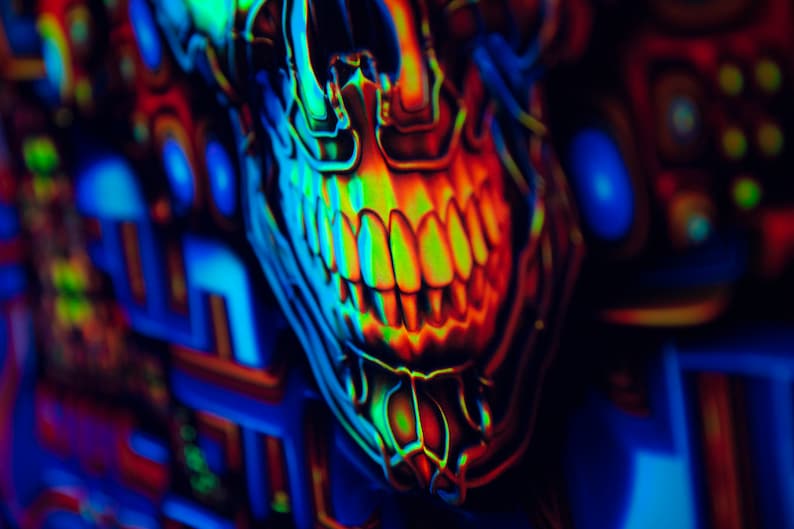 May include: A close-up of a neon green, blue and orange skull with a toothy grin. The skull is against a background of colourful geometric shapes.