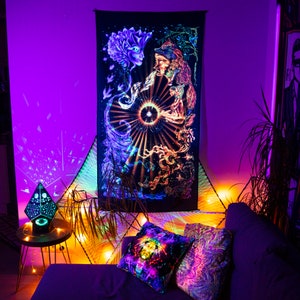 May include: A black tapestry with a psychedelic design featuring two figures, one with a flower-like head and the other with a human face, surrounded by swirling patterns and a bright light in the center.