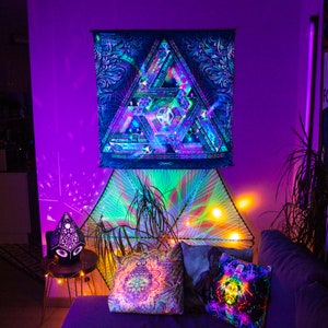 Peut inclure: Une tapisserie psych&eacute;d&eacute;lique avec un motif g&eacute;om&eacute;trique de triangles et de carr&eacute;s dans des tons de bleu, violet et vert. La tapisserie est accroch&eacute;e &agrave; un mur avec une lumi&egrave;re violette qui la &eacute;claire.