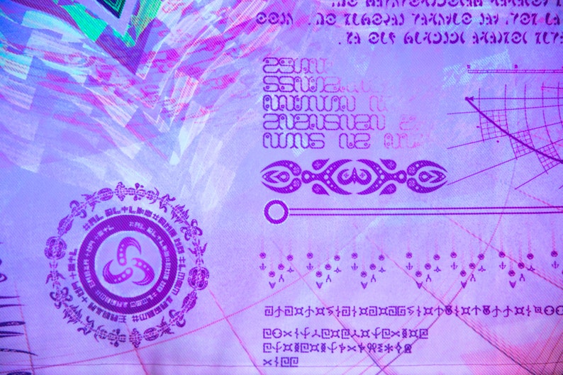 May include: A purple and white abstract design with a circular symbol in the center. The symbol is surrounded by a ring of smaller symbols. The design is on a textured background.
