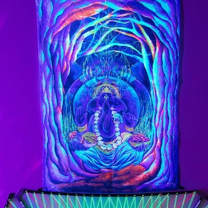 May include: Blacklight tapestry featuring a colorful depiction of the Hindu deity Ganesha, sitting in a meditative pose with a blue background and surrounded by trees. The tapestry is illuminated with a vibrant purple glow.