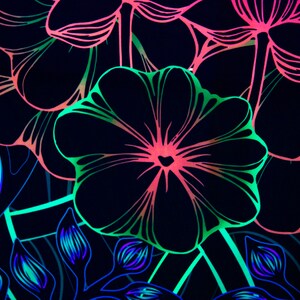 May include: A black background with a neon green, pink, and blue floral pattern. The flowers are stylized and have a graphic design.