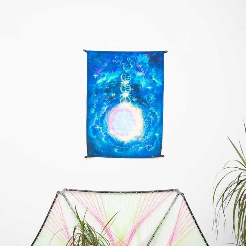 May include: A blue tapestry with a white circle in the center surrounded by a galaxy design. The circle has a pink and purple glow. The tapestry is hanging on a white wall.