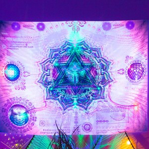 May include: A white tapestry with a purple, blue, and green mandala design. The mandala is surrounded by a white background with intricate patterns and symbols. The tapestry is illuminated with colorful lights.