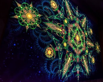 Op de afbeelding: Een zwart wandkleed met een groen, geel en oranje mandala-ontwerp. De mandala is omgeven door een zwarte achtergrond met witte sterren.