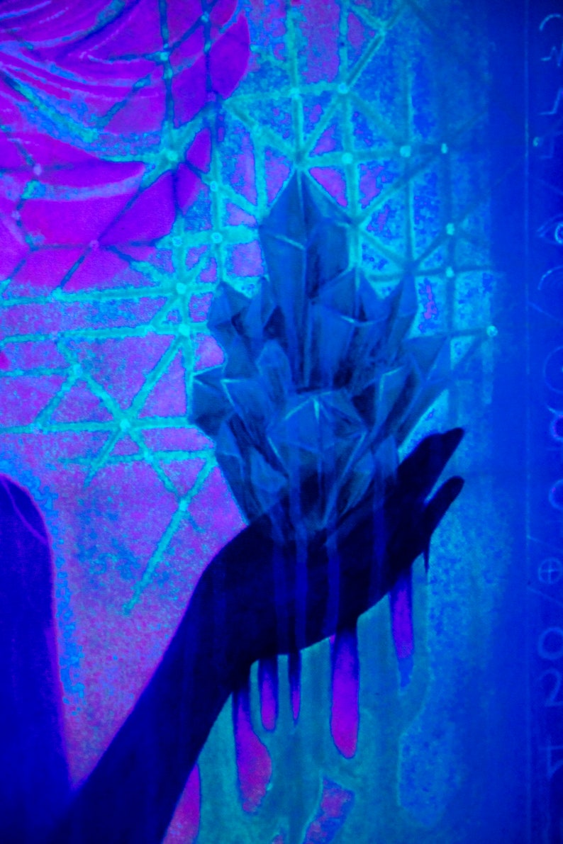 May include: A hand holding a large, blue crystal with a geometric shape. The hand and crystal are silhouetted against a background of purple and blue.