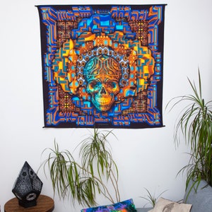 May include: A psychedelic tapestry featuring a skull with a blue and orange geometric pattern. The skull is surrounded by a complex, colourful design of overlapping shapes and lines.