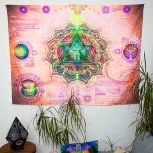 May include: A tapestry with a pink background and a large, colorful mandala in the center. The mandala features a geometric design with a green triangle in the center. The tapestry is surrounded by a border of intricate patterns and symbols.