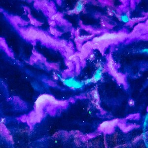 Puede incluir: Pintura abstracta de acuarela con matices azules y morados que se arremolinan, que se asemeja a una galaxia o nebulosa. El fondo es azul oscuro con puntos blancos dispersos.