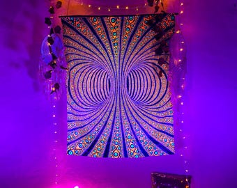 Peut inclure: Une tapisserie à lumière noire avec un motif symétrique vibrant présentant des cercles concentriques et des motifs géométriques dans des tons de bleu, d'orange et de sarcelle. La tapisserie est éclairée par une lumière violette.