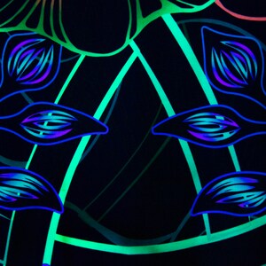 May include: A black background with a repeating pattern of blue and green floral designs. The design features stylized leaves and flowers with a glowing effect.