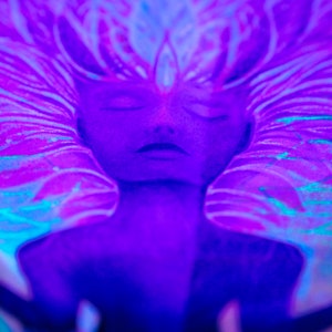 May include: A close-up of a painting depicting a person with their eyes closed. The painting is done in shades of blue and purple, with a swirling pattern around the person's head.
