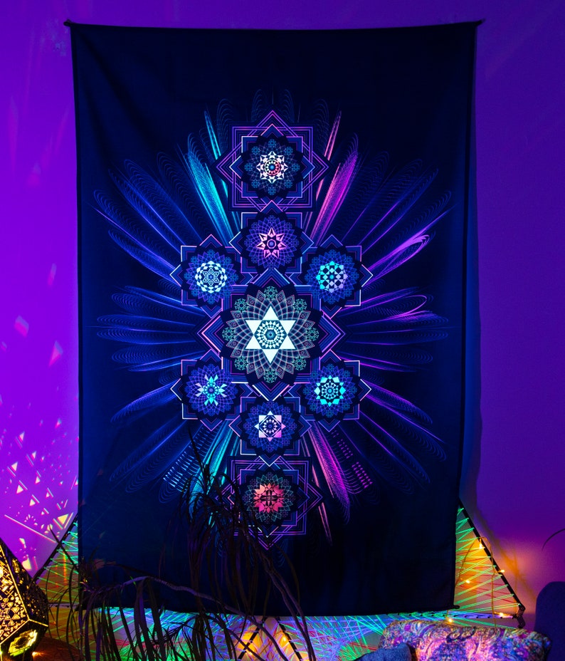 May include: A dark blue tapestry with a vibrant, geometric design. The artwork features seven star-like shapes in shades of blue, teal, and pink, arranged vertically. The design is accented with radiating lines, creating a glowing effect. The tapestry is likely used for wall decor.
