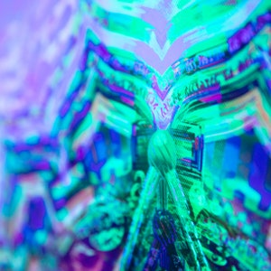 May include: Abstract digital art with a vibrant green, blue, and purple color scheme. The image is blurred and has a pixelated effect.
