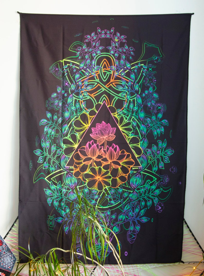 May include: A black tapestry with a rainbow-colored design of a triangle with a lotus flower inside, surrounded by leaves and vines.