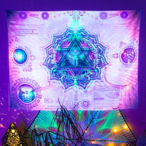 May include: A white tapestry with a colorful mandala design. The mandala features a triangle with a blue and green center and a purple and pink outer ring. The tapestry is surrounded by a white background with black text and symbols.