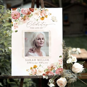 Peut inclure: Une pancarte commémorative blanche avec un cadre doré et une bordure florale. La pancarte indique "Celebrating the Life of Sarah Miller June 20, 1942 - May 4, 2021". Une photo de Sarah Miller est au centre de la pancarte.