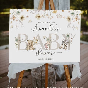 Pode incluir: Um cartaz de boas-vindas ao ch&aacute; de beb&ecirc; de Amanda com os personagens Winnie the Pooh e Piglet. O cartaz &eacute; branco com um design floral e o texto "Bem-vindo ao ch&aacute; de beb&ecirc; de Amanda" em fonte de caligrafia preta. A data "18 de mar&ccedil;o de 2023" est&aacute; impressa abaixo do texto.