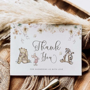 Pode incluir: Um cart&atilde;o de agradecimento com um design floral e ilustra&ccedil;&otilde;es do Winnie the Pooh, Piglet e Tigr&atilde;o. O cart&atilde;o diz "Obrigado" e "Por nos presentear com amor".