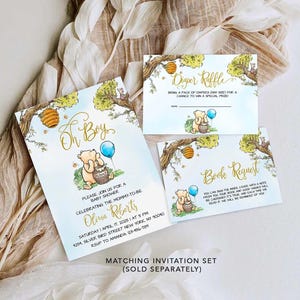 May include: A Winnie the Pooh themed baby shower invitation set with a blue and yellow color scheme. The invitation features a cartoon Winnie the Pooh holding a honey pot. The text on the invitation reads "Oh Boy!" and includes details for the baby shower. The set also includes a diaper raffle card and a book request card.