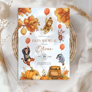 Puede incluir: Una tarjeta de invitación para baby shower con ilustraciones en acuarela de un oso, un cerdito, un tigre y un burro sosteniendo globos naranjas. El texto dice: PLEASE JOIN US FOR A BABY SHOWER HONORING Oliver SATURDAY AUG 28 2026 2 O'CLOCK APPLE ORCHARD PATH II SWEETBERRY VILLAGE, PO.