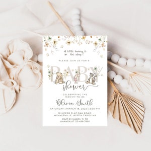Pode incluir: Um convite para um ch&aacute; de beb&ecirc; com tema Winnie the Pooh com uma borda floral. O convite diz "Por favor, junte-se a n&oacute;s para um Ch&aacute; de Beb&ecirc;" e inclui o nome "Olivia Smith", a data "18 de mar&ccedil;o de 2022" e a hora "15:00".