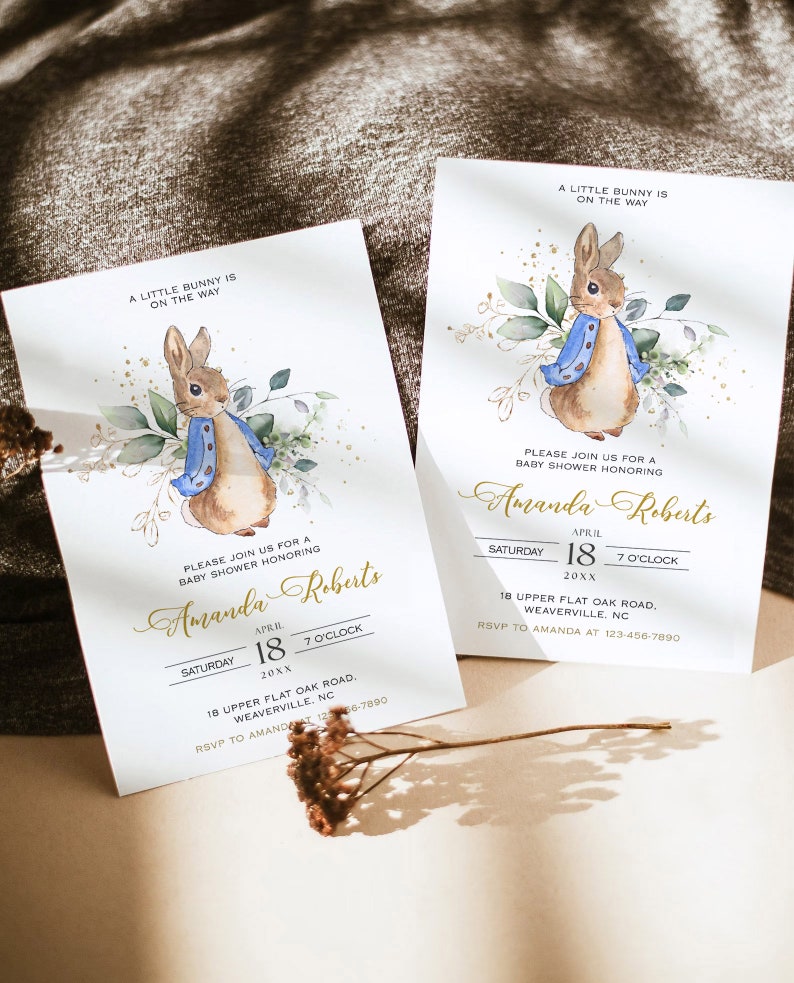 Peut inclure: Une invitation &agrave; une f&ecirc;te pr&eacute;natale avec une illustration aquarelle d'un lapin portant une veste bleue et entour&eacute; de verdure. L'invitation est pour Amanda Roberts et comprend la date, l'heure et le lieu de la f&ecirc;te.