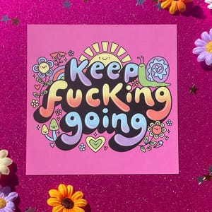 Könnte beinhalten: Ein rosa quadratischer Druck mit dem Schriftzug „Keep Fucking Going“ in bunten Buchstaben. Das Design umfasst eine lächelnde Sonne, einen Regenbogen, eine Schnecke, Blumen und Herzen. Dekorative Blumen und sternförmige Konfetti umgeben den Druck.
