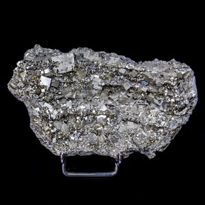 May include: A close-up of a pyrite specimen, also known as fool's gold, with a metallic, silver-gray color. The mineral displays a crystalline structure with many small, reflective, cubic formations. The specimen is mounted on a black stand against a black background.