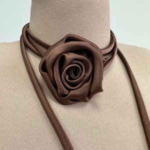 May include: A brown satin choker necklace with a large brown satin rose accent.
