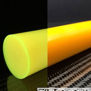 May include: A bright yellow, round, solid rod of composite material. The rod is glowing green under a blacklight. The rod is on a black surface with a carbon fiber pattern.