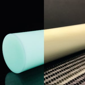Puede incluir: Primer plano de una varilla cilíndrica blanca con un acabado azul claro brillante. La varilla es parcialmente visible contra un fondo negro. La otra mitad de la varilla es visible contra un fondo de fibra de carbono negro y blanco. El texto "SKUR COMPOSITES" es visible en la esquina inferior derecha de la imagen.