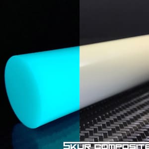 Puede incluir: Primer plano de una varilla turquesa que brilla en la oscuridad junto a una varilla blanca. Ambas varillas están sobre un fondo negro de fibra de carbono. El texto "SKUR COMPOSITES" es visible en la parte inferior de la imagen.