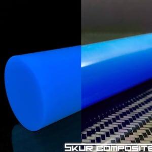 May include: A bright blue, round, solid rod of composite material. The rod is smooth and glossy. The rod is on a black surface with a carbon fiber pattern.