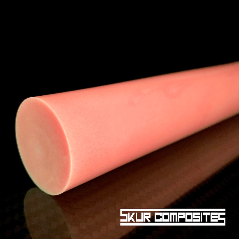 Może przedstawiać: Zbliżenie na r&oacute;żową, okrągłą, gładką, solidną pręt. Pręt jest wykonany z materiału kompozytowego i ma średnicę około 2,5 cm.