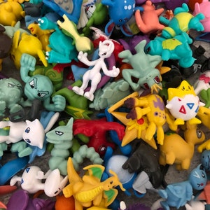 Może przedstawiać: Duża kolekcja kolorowych plastikowych figurek r&oacute;żnych postaci Pokemon&oacute;w. Figurki są w r&oacute;żnych pozach i wyrażają r&oacute;żne emocje, a niekt&oacute;re trzymają przedmioty, takie jak Pok&eacute;balle.