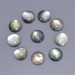 Peut inclure: Dix cabochons ronds en nacre noire et blanche irisée. Les cabochons mesurent environ 2,5 cm de diamètre.