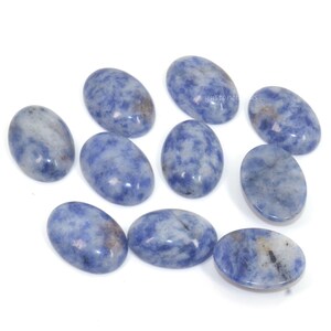 Pu&ograve; includere: Dieci cabochon ovali in pietra preziosa blu e bianca. I cabochon hanno un motivo marmoreo e sono lisci e lucidi.