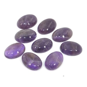 May include: Ten oval-shaped amethyst gemstones in various shades of purple. The stones are smooth and polished, with a glossy finish.