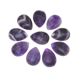 May include: Ten teardrop-shaped amethyst gemstones arranged in a circular pattern. The stones display a mix of deep purple and white hues, with natural veining patterns visible on each polished surface. The gemstones are set against a white background.