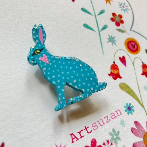 Hand painted wooden Hare brooch, Sitting hare design painted in beautiful blues and whites.Glitter detail with gloss resin finish.