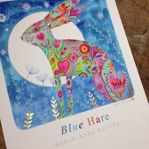Op de afbeelding: Een kleurrijk aquarel schilderij van een blauwe haas met een maan en sterren op de achtergrond. De haas is gemaakt van verschillende bloemmotieven en harten. De tekst "Blue Hare" en "Susan Anne Reeves" staat onder de haas.
