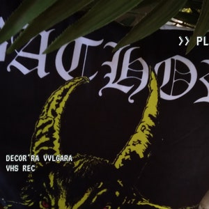 Pode incluir: Travesseiro preto com estampa gráfica amarela e o texto "BATHORY" em letras góticas brancas. O texto "DECOR'RA VVLCARA VHS REC" está impresso em branco abaixo do gráfico.