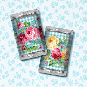 May include: Two silver foil-wrapped chocolate bars with floral patterned wrappers. The wrappers feature a blue and white gingham pattern with pink, yellow, and blue flowers.