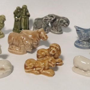 Może przedstawiać: Kolekcja 12 miniaturowych figurek ceramicznych przedstawiających r&oacute;żne zwierzęta, w tym koguta, krowę, lwa, słonia, łabędzia i owcę. Figurki są pomalowane w r&oacute;żnych kolorach, w tym zielonym, brązowym, niebieskim i białym.