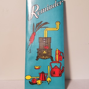 May include: A teal blue reminder card with a black and brown stove, red teapot, yellow spoon, and red carrots. The text "Reminder" is written in white cursive on the top of the card.
